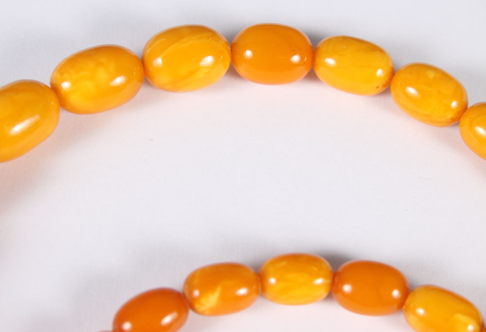 A graduated "egg yolk" amber bead necklace, 31" long, the largest bead 1 1/4" wide, 87.6g - Bild 6 aus 14