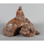 A 19th Century Chinese pottery model of a seated figure on a Dog of Fo, 10 1/2" long (a/f)