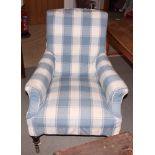 A Victorian easy chair, upholstered in a blue check, on turned supports