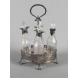 A Georgian silver cruet stand with pierced decoration and bright cut engraving with four silver