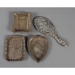 A miniature continental silver hand-mirror with embossed decoration and three silver pin trays