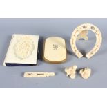 A 19th Century carved ivory covered aide-memoire holder, an ivory horseshoe photograph frame, a