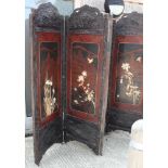 A 19th Century oriental carved hardwood framed screen, inset four red and black lacquered panels