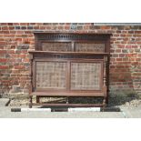 An oak double bedstead decorated cane panels with metal side rails