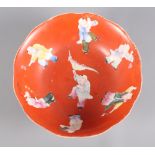 A 19th Century porcelain bowl decorated with figures on an orange ground