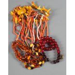 An assortment of necklaces, pendants and a brooch, including coral and amber
