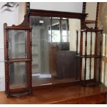 A late 19th Century walnut framed over mantel mirror, fitted small display shelves, 44" wide