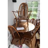 An Ercol Golden Dawn circular extending dining table, 43" dia, and a set of six (4+2) matching