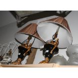 A pair of black and gilt two-handled vase shaped table lamps with brown pleated shades