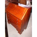 A Georgian style mahogany bureau decorated stringing, fitted four drawers, on ogee bracket supports,