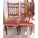 A set of four early 20th Century dining chairs with pierced splats and stuffed over seats,