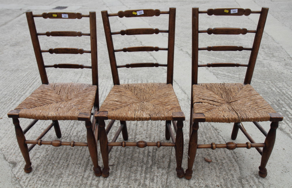 A set of three 19th Century rush seat ladder back standard chairs