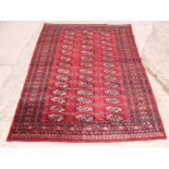 A Bokhara rug decorated 42 medallions on a red ground, 72" x 48" approx
