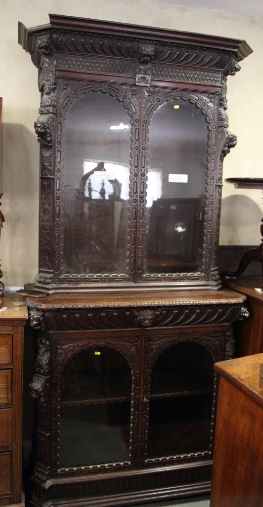 A late 19th Century dark stained and carved oak two-section bookcase, fitted frieze drawer, 42"