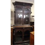 A late 19th Century dark stained and carved oak two-section bookcase, fitted frieze drawer, 42"