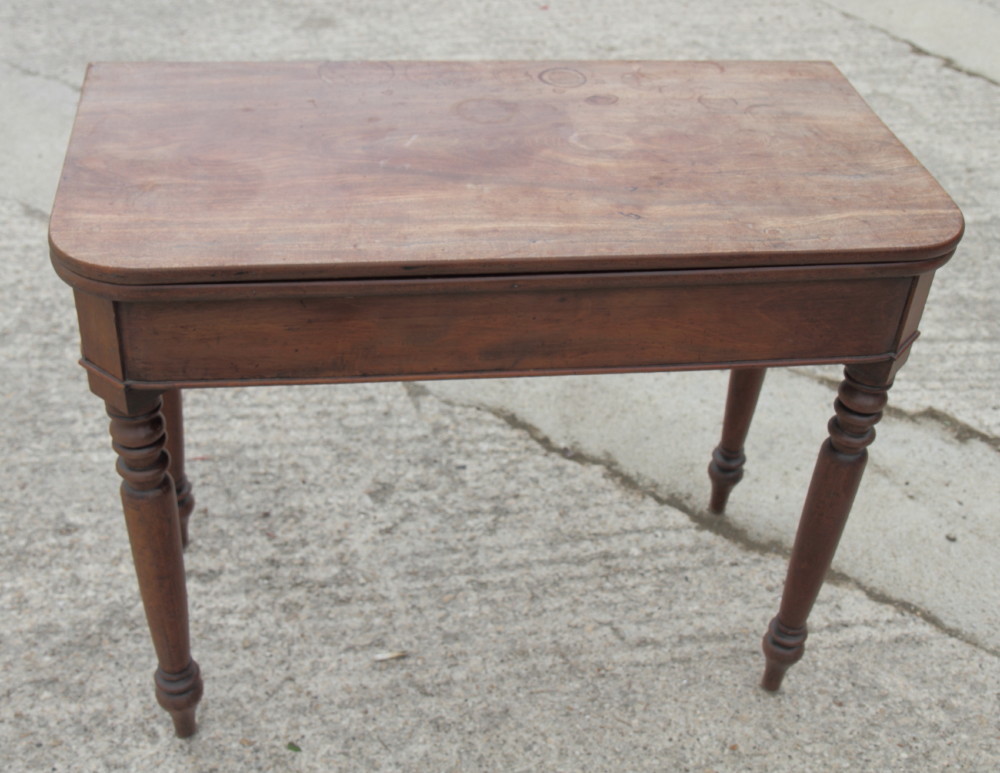 A 19th Century mahogany fold-over tea table, on turned supports, 36" wide