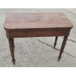 A 19th Century mahogany fold-over tea table, on turned supports, 36" wide