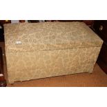 A box Ottoman upholstered in a green fabric