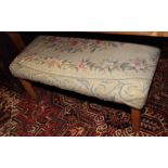 A rectangular footstool, upholstered in a floral tapestry, on short square supports, 39" x 29"