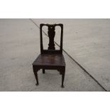 An 18th Century oak standard chair with shaped splat and panelled wooden seat, on pole turned