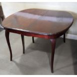 An extending mahogany dining table with two leaves, on cabriole supports, 82" x 43" (when fully