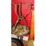 A circular metal framed garden table with circular weathered marble top (cracked) and a circular