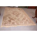 A Persian design carpet decorated central medallion and spandrels on a beige ground with border,