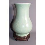 A K'ang Hsi incised celadon glazed vase, 12 1/2" high, on carved hardwood stand
