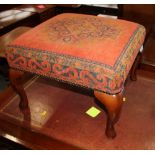 A square footstool with upholstered top, on cabriole supports