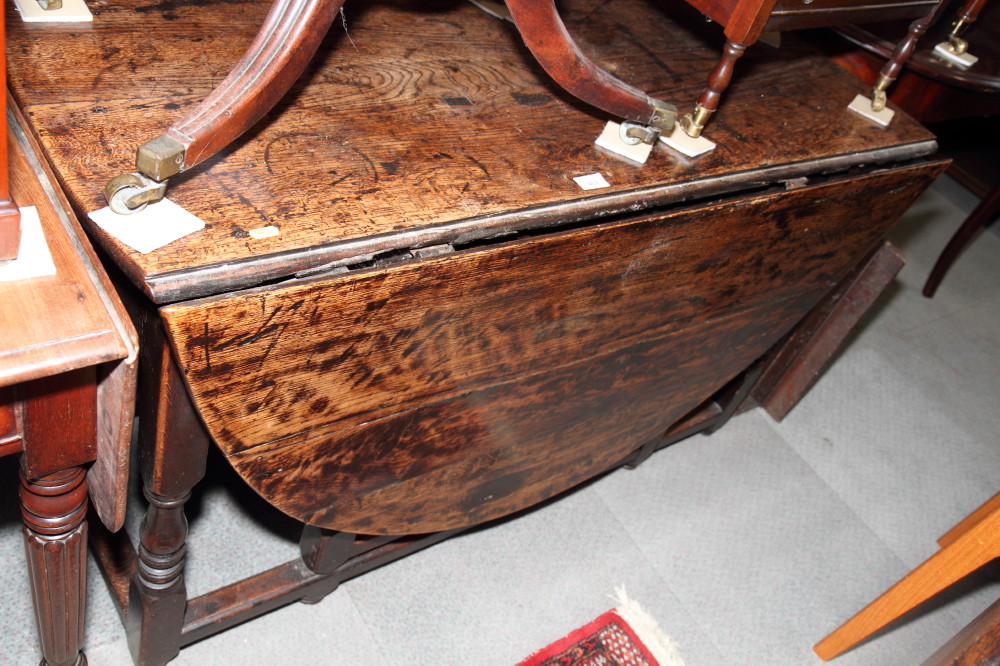 A 17th Century style oval oak drop leaf dining table, on turned underframe, 61" x 48" when fully