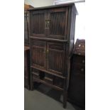 A 19th Century Chinese three-tier dark stained cabinet, the upper stages enclosed two reeded