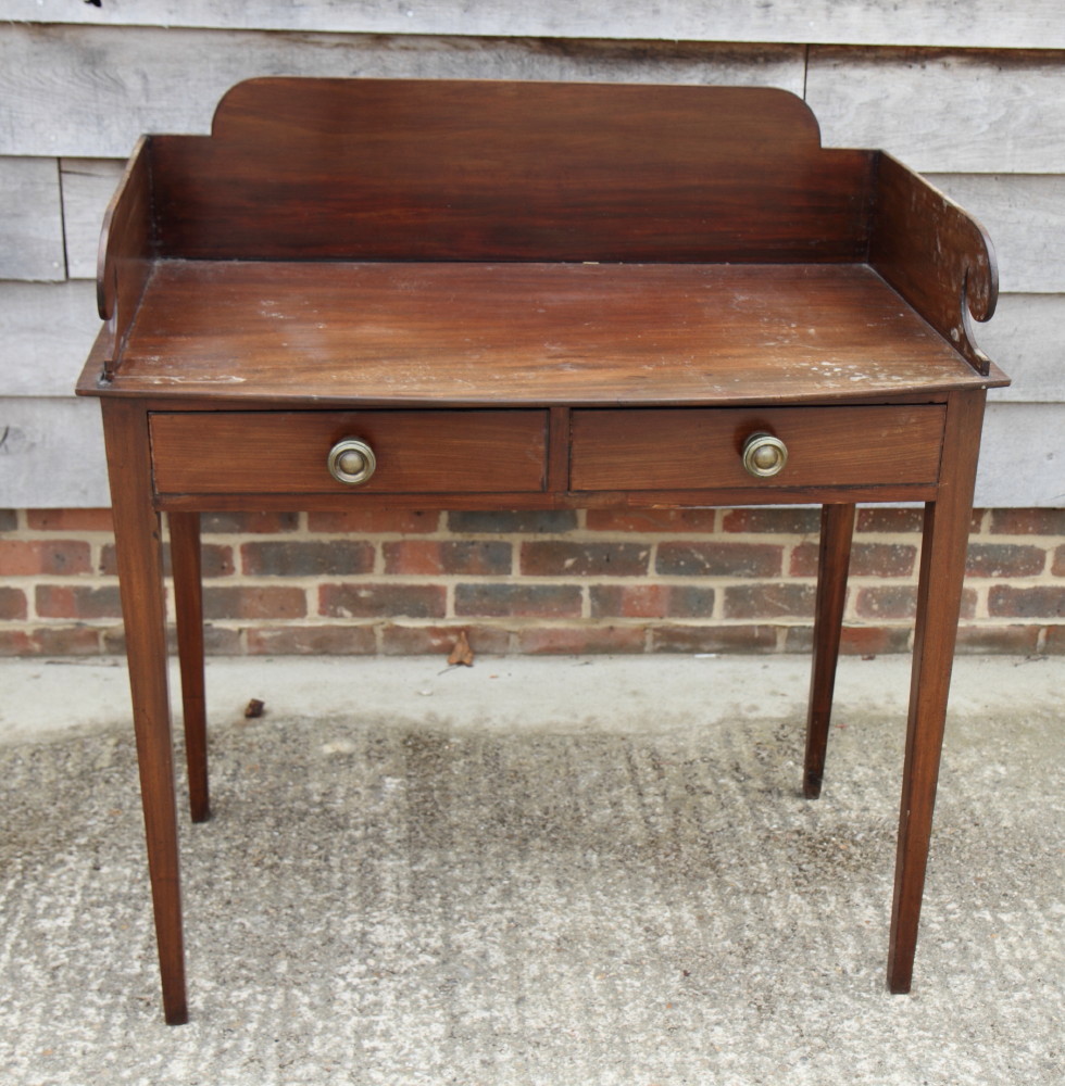 A 19th Century mahogany washstand with polished top, three-quarter gallery, two frieze drawers, on
