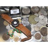 A collection of coins and a silver mounted watch with leather strap