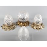 A pair of ovoid cut glass ceiling light shades with gilt metal mounts, another spherical diamond cut