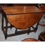 An antique oak oval drop leaf table, on gate leg supports, 42" wide