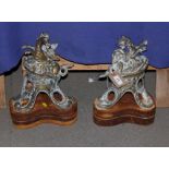 A pair of brass door stops, cast as winged griffins, on cast iron bases, 14" high