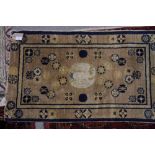 A Chinese rug decorated blue roundels and central bird on a beige ground, 37" x 22 1/2" approx