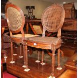 A pair of Louis XVI style standard chairs with oval cane backs and seats, on turned and fluted