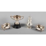 A pair of silver salts with gadrooned borders, a silver pepper pot and a miniature two-handled