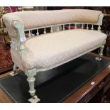 A Victorian two-seat settee with padded back rail on spindle supports and stuffed over seat, on