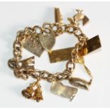 A 9ct gold curb link bracelet mounted with numerous gold charms, 44.7g