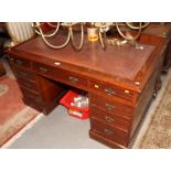 A late 19th Century walnut twin pedestal desk with red tooled leather top, fitted nine drawers,