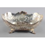 A silver bread basket with cast and pierced decoration, raised on four scrolled supports, 15.6oz