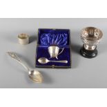 A cased silver egg cup and spoon, an embossed silver pedestal bowl, on ebonised plinth, a