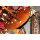 A mahogany oval dining table, on turned column and tripod splay supports, 52" dia