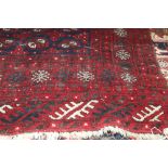 A Bokhara rug decorated three rows of octagonal guls on a red and blue ground with numerous border