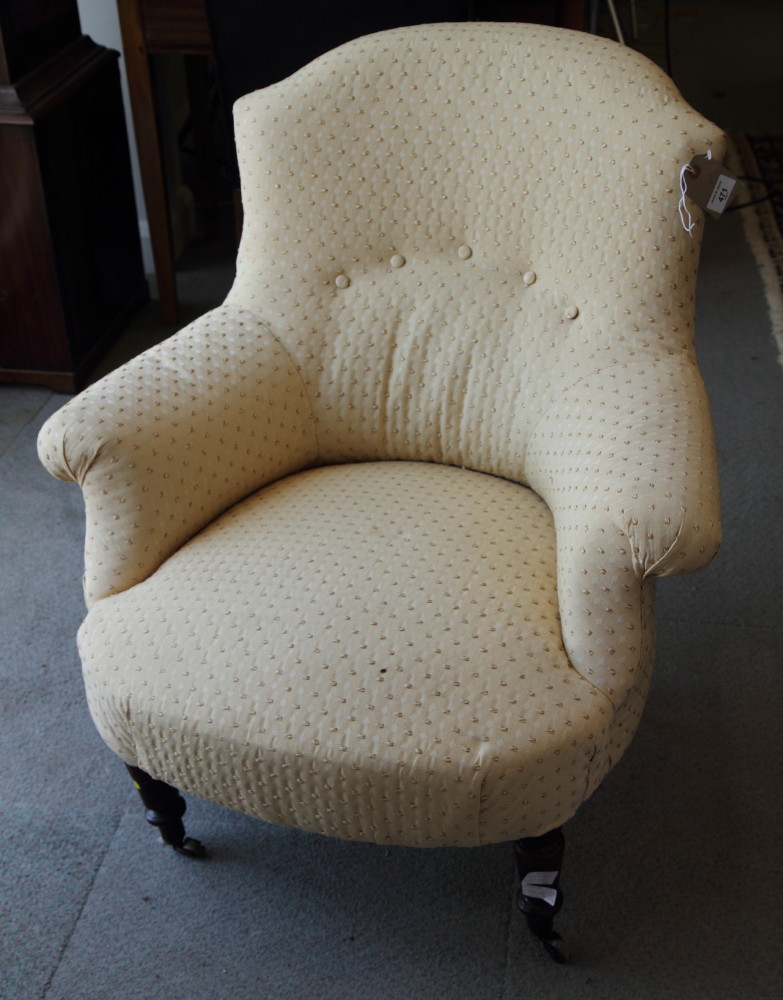 A Victorian low seat armchair, upholstered in a cream and gold fabric