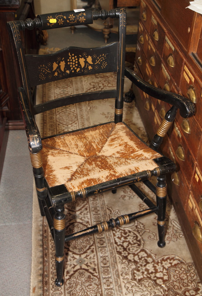 An ebonised and gilt decorated elbow chair, on turned and stretchered supports