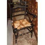 An ebonised and gilt decorated elbow chair, on turned and stretchered supports
