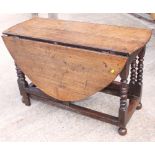 An 18th Century oval oak drop leaf dining table, on turned underframe, opening to 52" x 47"